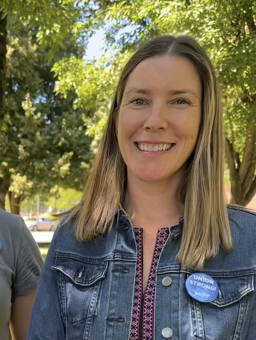 A photo of Michelle DuBarry wearing a jean jacket, maroon shirt, and FFAP Union Strong Button 
